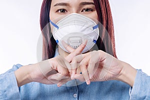 Woman wearing protection face mask for protected virus and air pollution making cross finger stop sign gesture disease,