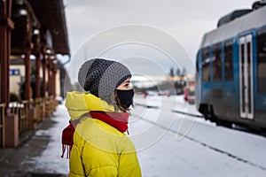 Woman wearing protective face mask and traveling by train during covid-19 pandemic
