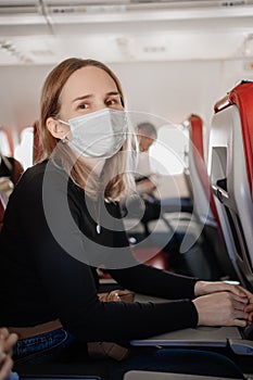 a woman wearing a protective mask on board the plane.