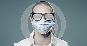 Woman wearing a surgical mask and fogged up glasses