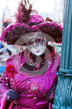 Masked woman wearing a purple hat at the Carnival, Venice, Italy