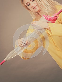 Woman wearing raincoat closing umbrella