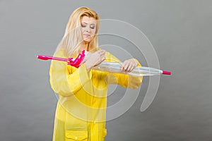 Woman wearing raincoat closing umbrella