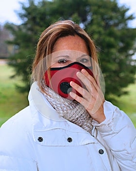 Woman wearing a red antiviral face mask to protect from sickness.