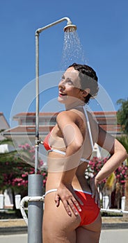 Woman wearing red bathing suit takes shower