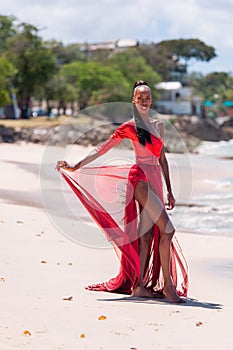 Woman Wearing Red Bikini and Dress on a tropical beach. Remote tropical beach in Barbados, Caribbean Sea. Black. Portrait