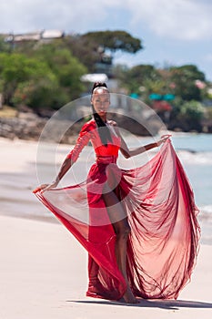 Woman Wearing Red Bikini and Dress on a tropical beach. Remote tropical beach in Barbados, Caribbean Sea. Black. Portrait