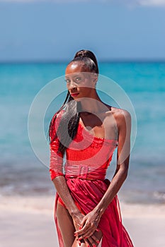 Woman Wearing Red Bikini on a tropical beach. Remote tropical beach in Barbados, Caribbean Sea. Black. Portrait