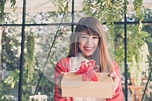 woman wearing red cardigan hold gift box to a man. hand give present box. christmas, new year holiday.