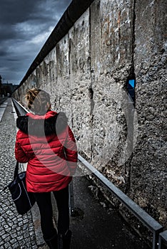 Woman wearing red jacket visits remains of Berlin Wall photo