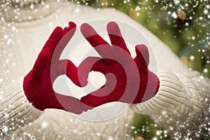 Woman Wearing Red Mittens Holding Out a Heart Hand Sign