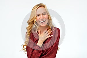 Woman wearing red shirt laughing broadly glad to receive compliments