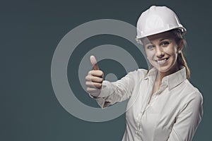 Woman wearing a safety helmet and giving a thumbs up