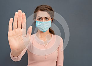 Woman wearing sanitary mask, holding hands up gesture isolated