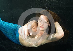 Woman wearing shell bikini and mermaid tale.