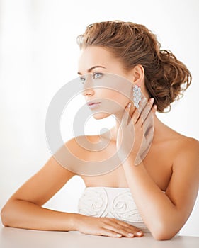 Žena nosenie lesklý diamant náušnice 