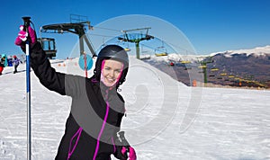 Woman wearing ski equipment and skiing in snowing mountains