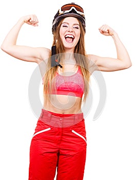 Woman wearing ski suit, helmet with goggles showing muscles