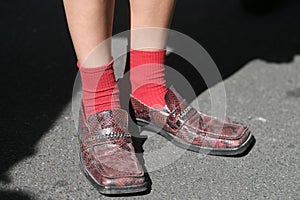 Woman wearing snake leather shoes and red socks