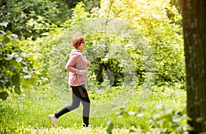 Woman wearing sportswear and running in forest at mountain