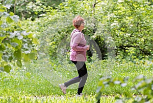 Woman wearing sportswear and running in forest at mountain