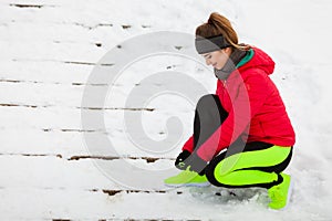 Woman wearing sportswear tying shoes