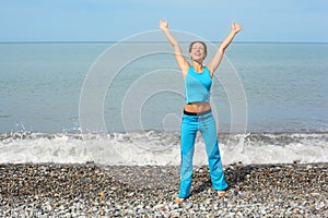 Woman wearing sporty clothers with raised hands photo