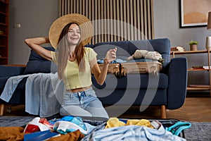 Woman wearing straw beach hat dreaming in anticipation of upcoming trip