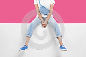 Woman wearing stylish shoes on color background