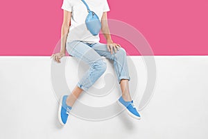 Woman wearing stylish shoes on color background