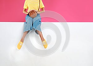 Woman wearing stylish shoes on color background