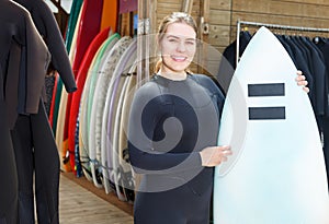 woman wearing surf suit with surfboard