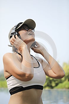 woman wearing swimming wuit and listening sound from headphone