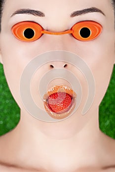Woman wearing tanning bed glasses with strawberry