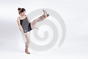 woman wearing top and short throwin a kick in a white studio