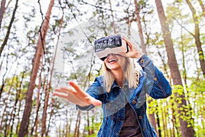 Woman wearing virtual reality goggles outside in spring nature