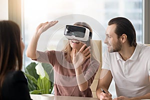 Woman wearing virtual reality headset, team developing VR glasse