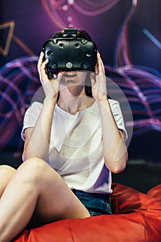 Woman wearing VR goggles. She is fascinated about what she sees