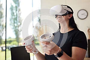 Woman Wearing VR Headset Holding Controllers Gaming At Home