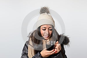 Woman wearing winter cap drinking hot beverage