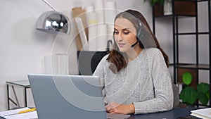 woman wearing wireless headset using a laptop computer for communication