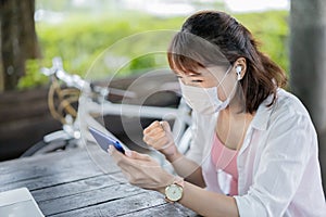 Woman wears earbud use smartphone