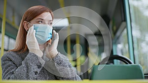 Woman wears medical mask to protect against coronavirus infection and puts his hand on handrail when traveling on public