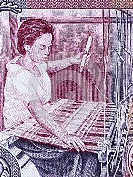 Woman weaving a rug a portrait from Cambodian money