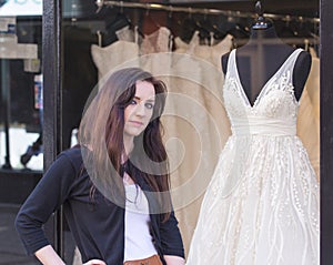 Woman with wedding dress shop window