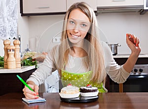 Woman weighing cakes on kitchen scales