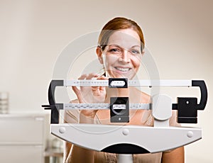 Woman weighing herself in doctor office photo