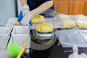 Woman weighing homemade pumpkin bread dough on a scale.