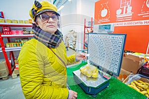 Woman weighs apples at the grocery store