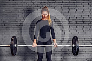 Woman with weight barbell doing deadlift exercise